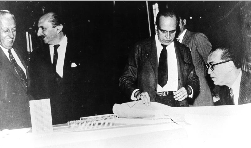 Israel Pinheiro (1° da esq.), Lúcio Costa, Oscar Niemeyer e Juscelino Kubitsheck examinam a maquete da Praça dos Três Poderes. S.I., s.d. Fundação Oscar Niemeyer.