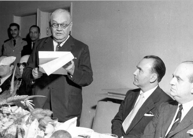 Nero Moura e Luis Gallotti assistem a discurso de José Linhares durante homenagem prestada ao poder judiciário pela Força Aérrea Brasileira, na Base Aérea de Santa Cruz. Rio de Janeiro, 1 de junho de 1954. FGV/CPDOC, Arq. Nero Moura.